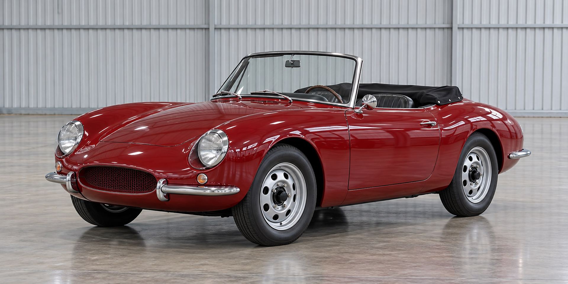 Restaurierter roter Roadster in Seitenansicht in einer hellen Halle